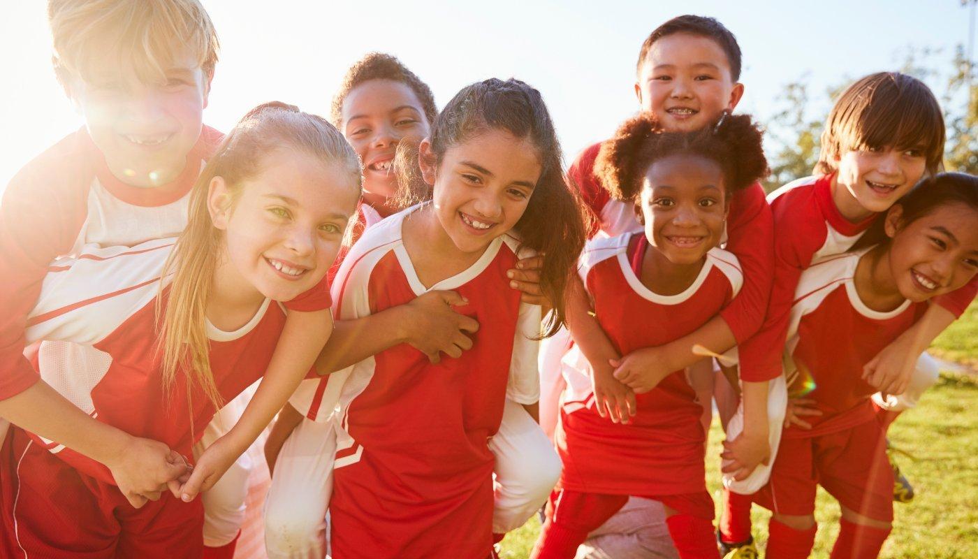 group of kids wearing sports jerseys at soccer game